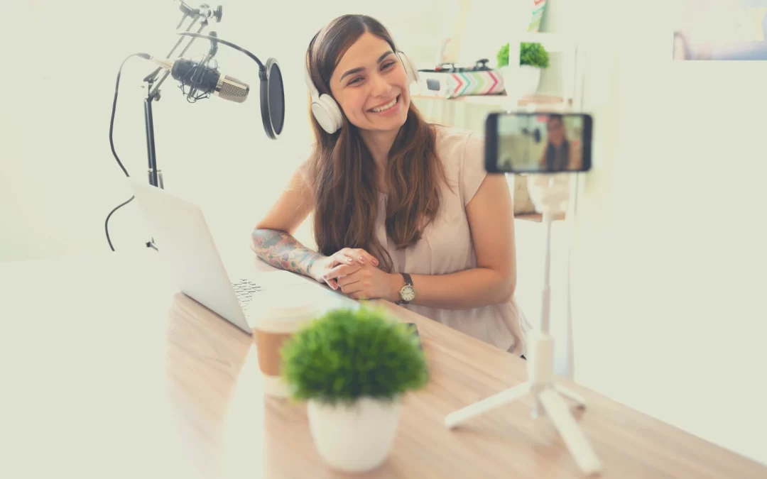 Should you have a video-first podcasting strategy for your brand? A woman smiles for the camera while speaking into a microphone.